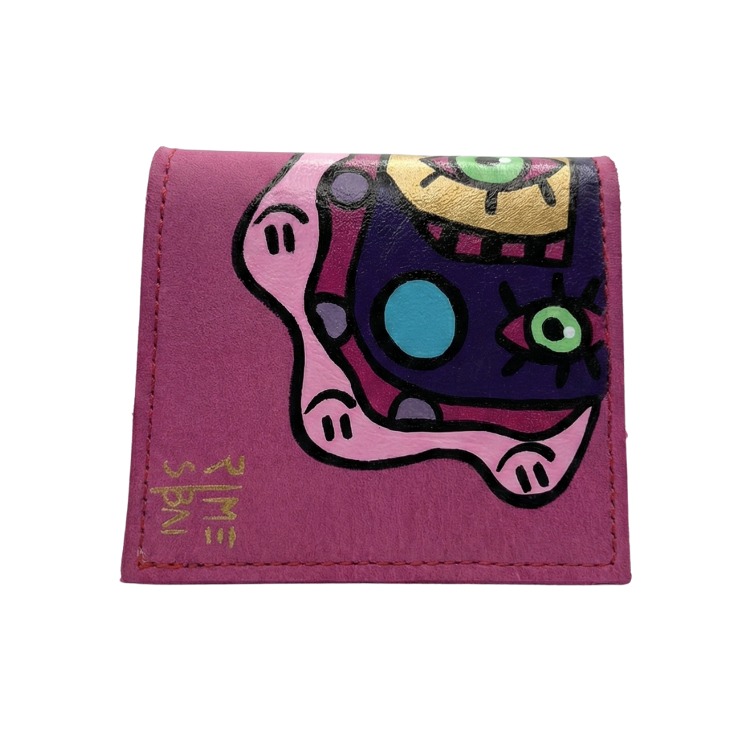 Hand-painted pink leather wallet with cubist abstract portrait, green cheek, and white polka dots. Signed by Rime Sbai.