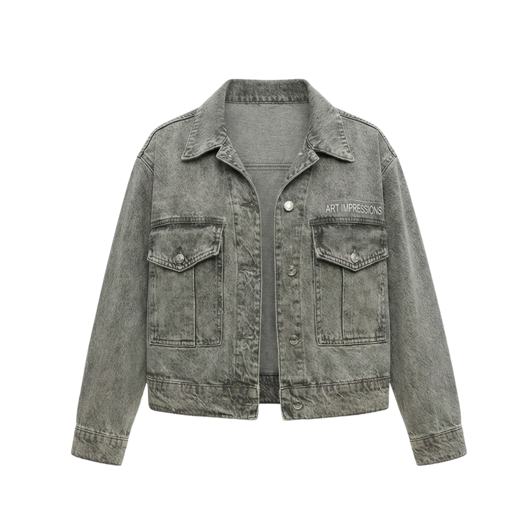 Front view of a woman wearing the grey boxy trucker denim jacket with Artgressions logo detail.